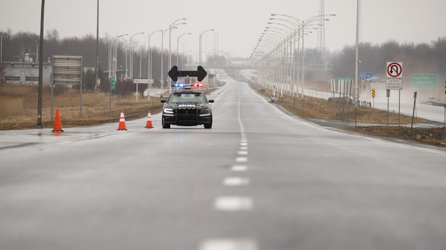 Une voiture de police est seule sur la longue route menant vers la frontière américaine.