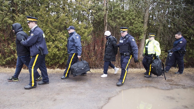 La GRC avec des migrants qui tentent de traverser la frontière, à Hemmingford