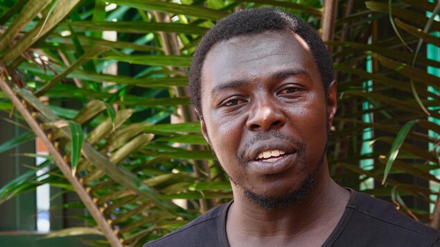 Fulgence Mapeka pose devant des feuilles de palmier. Fulgence Mapeka pose devant des feuilles de palmier.