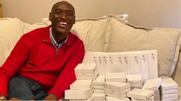 Portrait de Fulgence Ndagijimana tout sourire, assis sur un canapé.