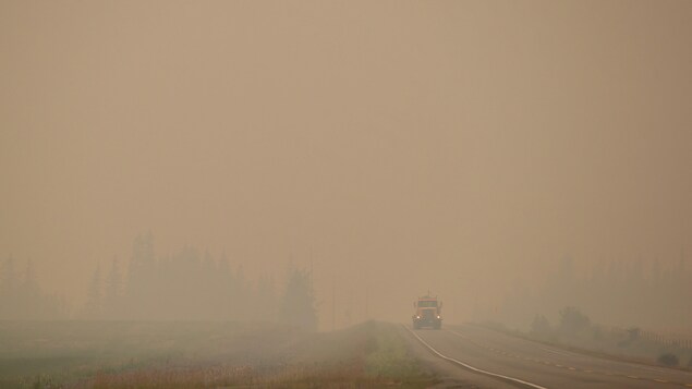Un camion roule sur l'autoroute 27 dans un épais nuage de fumée entre Vanderhoof et Fort St. James Un camion roule sur l'autoroute 27 dans un épais nuage de fumée entre Vanderhoof et Fort St. James