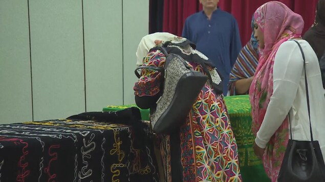 Une femme avec un foulard pleure sur un cercueil.