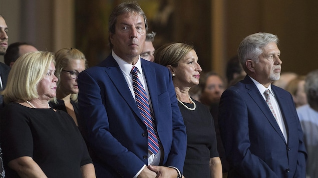 Deux hommes et deux femmes sur un même banc d'église. Deux hommes et deux femmes sur un même banc d'église.