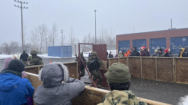 Des hommes des forces armées canadiennes font une simulation d'une entrée dans un bâtiment.