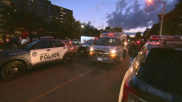 Une ambulance et des autopatrouilles à la tombée de la nuit.