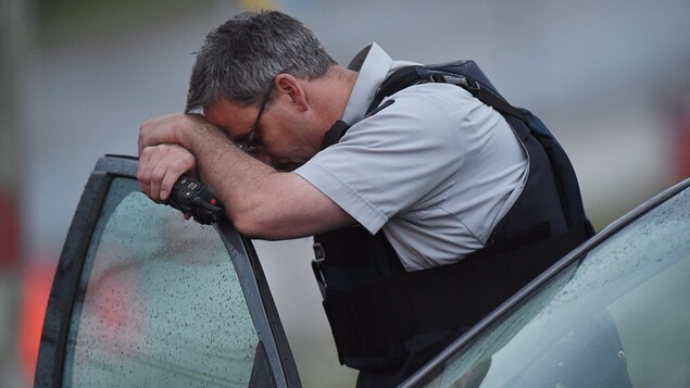 Un policier à côté d'une voiture