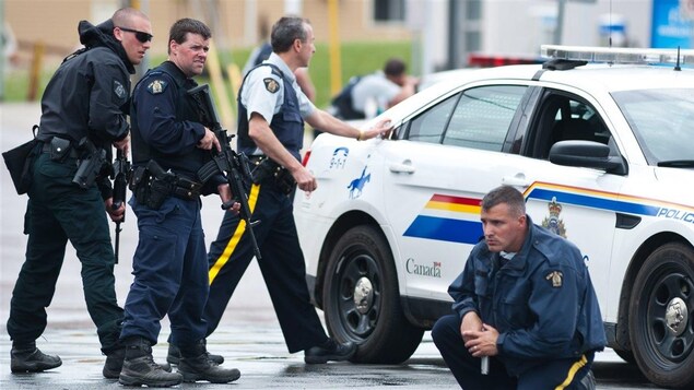 Des policiers armés gardent une rue