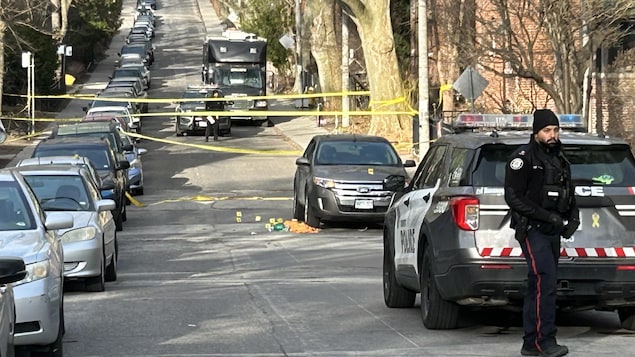 Des policiers près d'une banderole jaune bloquant une rue à Toronto, le 16 avril 2025, à la suite de la fusillade.