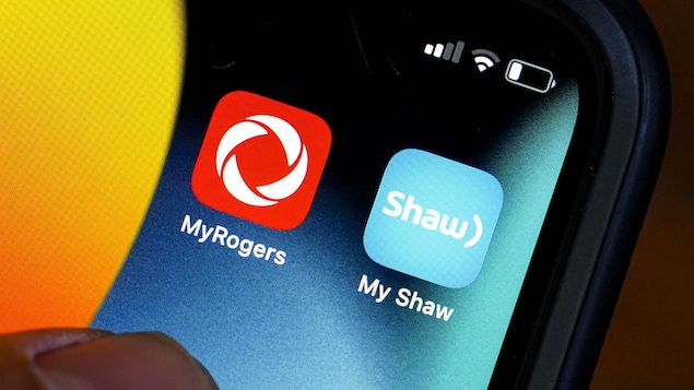 Rogers and Shaw applications are seen on a cellphone in Ottawa on May 9, 2022. The Competition Bureau sought to block the companies' recent merger, fuelling criticism of Canada's competition laws.