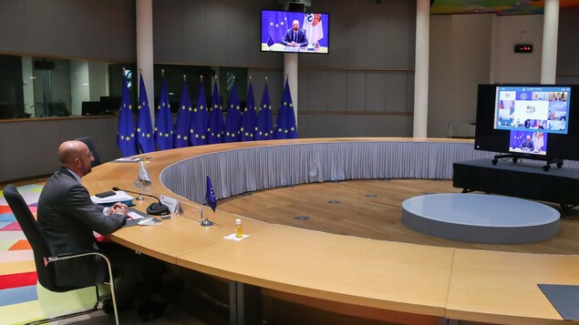 Charles Michel, président du Conseil européen, assis à une table vide devant un écran.