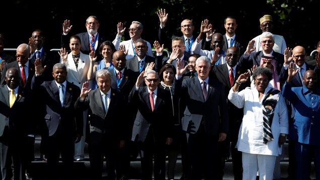 Les dirigeants des pays du G77 posent pour une photo de groupe, une main dans les airs.