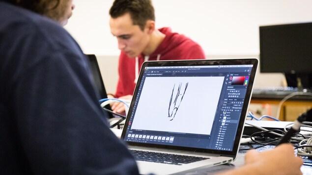 Un jeune homme de dos en train de dessiner à l'ordinateur à l'aide d'une tablette graphique. Un jeune homme de dos en train de dessiner à l'ordinateur à l'aide d'une tablette graphique.