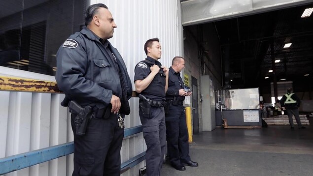 3 gardes de sécurités se tiennent dos à un mur de l'aéroport 3 gardes de sécurités se tiennent dos à un mur de l'aéroport