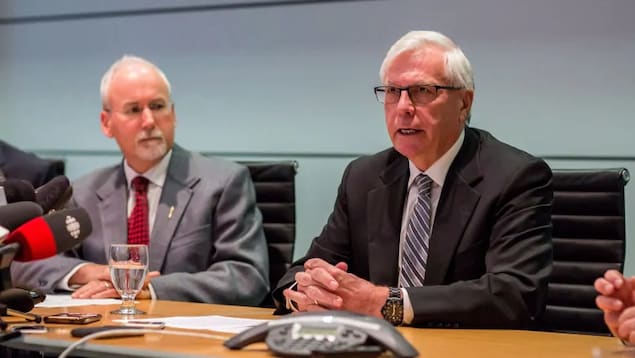 Deux hommes s'expriment lors d'une conférence de presse.