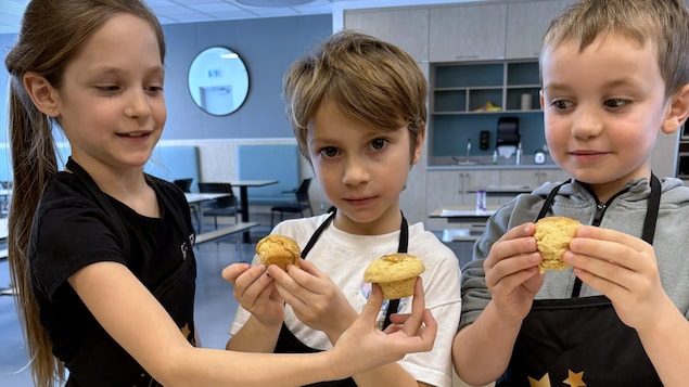 Les élèves tiennent leur petit gâteau dans leur main.