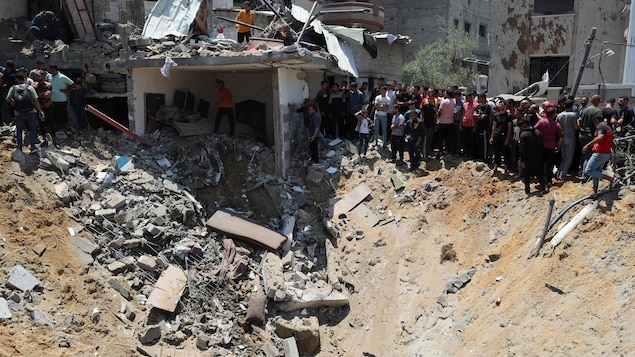 Des Palestiniens cherchent des victimes sur le site d'une frappe israélienne sur une maison.