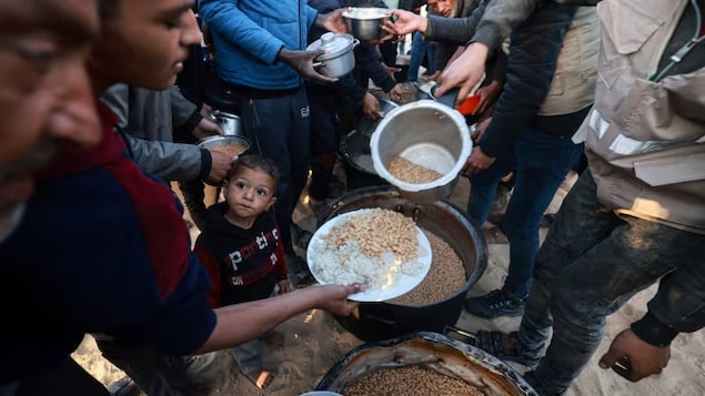 Displaced Palestinians collect food donated by a charity before iftar, the breaking of fast, on the first day of Ramadan, in Rafah in the southern Gaza Strip, on March 11. Amid the ongoing Israel-Hamas war, food for iftar has been hard to come by. 