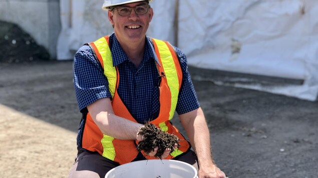 Un homme montre du compost.