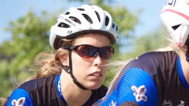 La paracycliste amossoise Geneviève Ouellet pédale sur un vélo en tandem derrière une autre athlète.