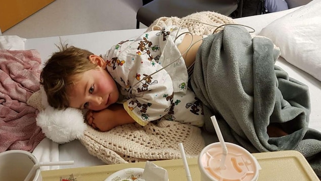 Un garçon de 4 ans allongé dans un lit d'hôpital.