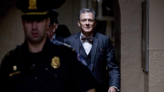 George Kent en train de marcher et entouré d'agents de sécurité.