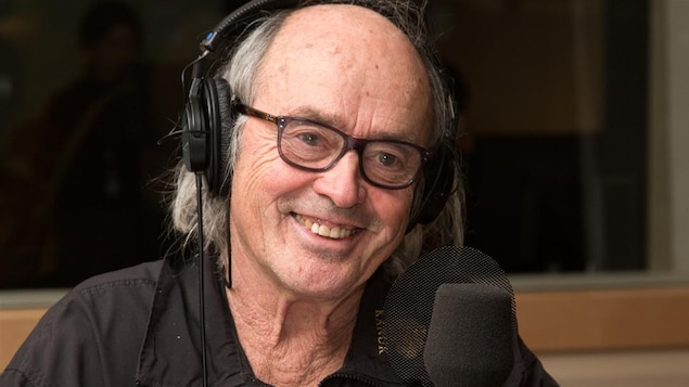 Georges Brossard, un casque d'écoute sur la tête.