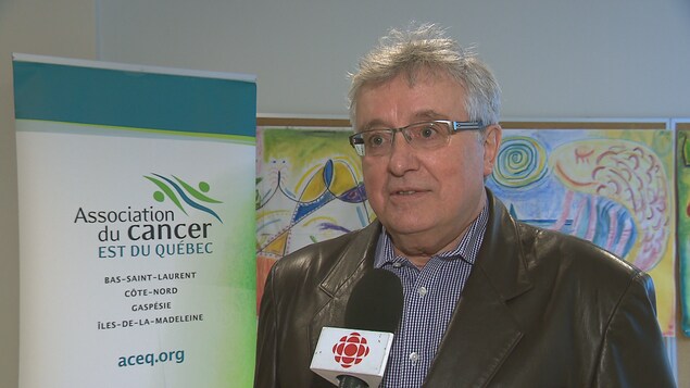 Dr Georges Levesque, l'un des administrateur de l'Association du cancer de l'est du Québec pose devant une pancarte de l'association. Dr Georges Levesque, l'un des administrateur de l'Association du cancer de l'est du Québec pose devant une pancarte de l'association.