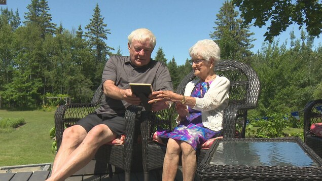 Gérard Cormier et Ernestine McDermott-Derry sur des chaises dans un jardin.