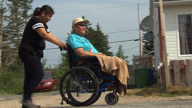 Poussé par Nathalie Michel, Gérard Pinette fait sa promenade matinale dans les rues de Maliotenam.