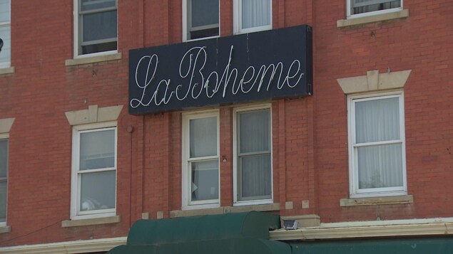 La façade de l'édifice Gibbard est ornée par l'enseigne du café La Bohème. La façade de l'édifice Gibbard est ornée par l'enseigne du café La Bohème.