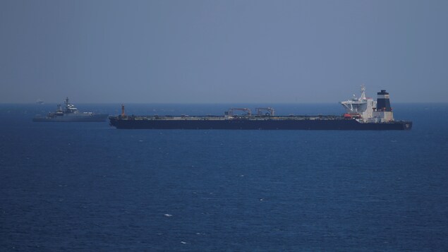 Un pétrolier et une frégate se font face au large d'une mer.