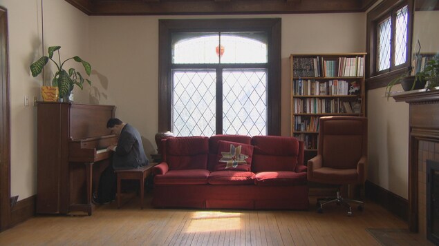 Une vieille maison et un homme joue du piano.