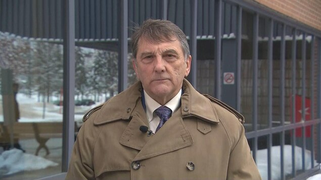 Gilles Lanteigne à l'extérieur vêtu d'un manteau d'hiver, devant un édifice.