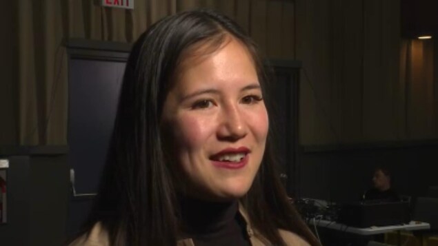 Une jeune femme se tient dans une salle de cinéma. Une jeune femme se tient dans une salle de cinéma.