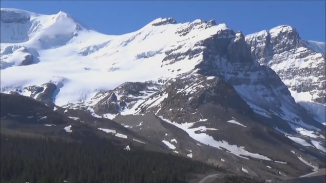 Une montagne partiellement recouverte de neige sous un ciel dégagé.