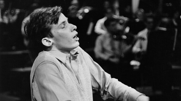 Glenn Gould semble en extase devant son piano.