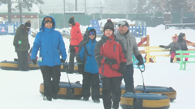 Une famille tire des tubes gonflables au Village Vacances Valcartier dans la région de Québec.