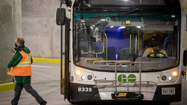 Un travailleur qui sort d'un autobus de GO Transit. 