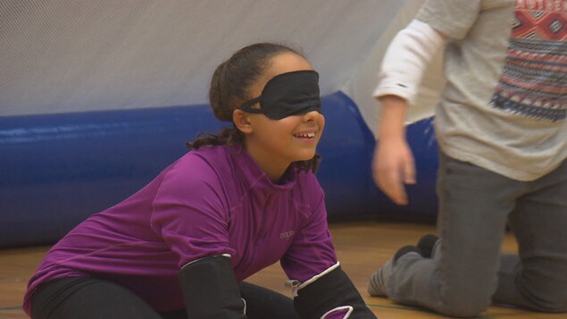 Une petite fille avec un bandage sur les yeux.