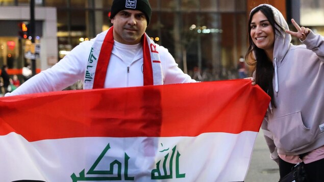 شاب وصبية يحملان علم العراق.
