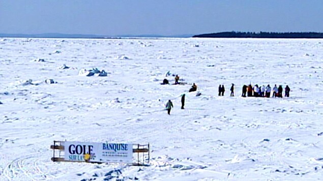 Des gens massés sur le fleuve gelé, entre Rimouski et l'île Saint-Barnabé, en février 2005. L'événement Golf sur la banquise s'est tenu trois hivers de suite, en 2003, 2004 et 2005.