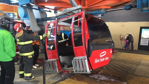 Une gondole rouge lettrée avec le logo du Mont-Sainte-Anne est sujet à l'inspection du service d'incendie.