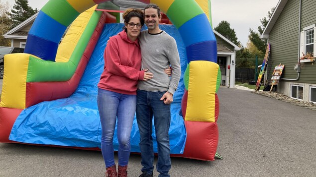 Un homme et une femme devant un jeu gonflable multicolore.