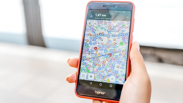 Une femme tient un téléphone dans sa main.