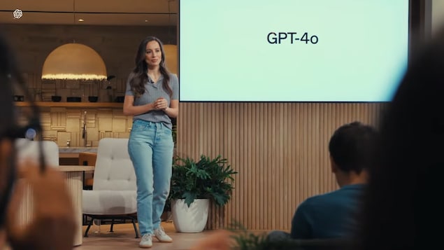 Une femme debout sur une scène dévoile le modèle de langage «GPT-4o». 