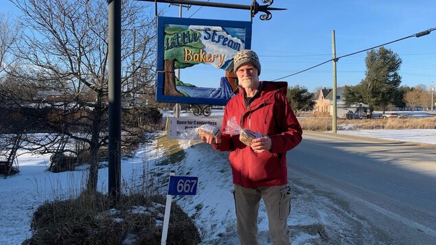 A man stands by the road in winter.