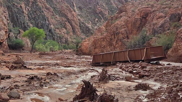 La partie supérieure d'un pont repose dans le lit d'un canyon qui a été parcouru par une coulée de boue.