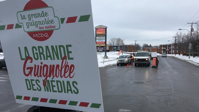 Pancarte avec des gens qui parlent à des automobilistes.
