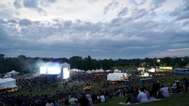 Une foule assiste à un concert en plein air.