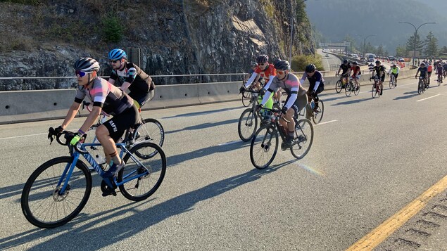 Une dizaine de cyclistes du GranFondo pédalent en montée sur la Transcanadienne à la hauteur de Horseshoe Bay à West Vancouver le 10 septembre 2022.